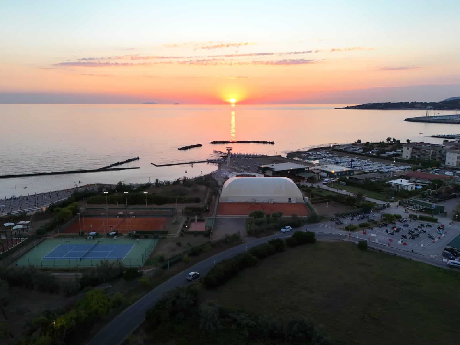 tramonto sul mare con porticciolo